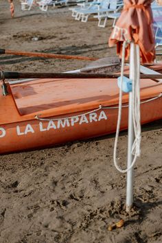 an orange boat sitting on top of a sandy beach