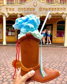 a hand is holding up a toy boot with ice cream on it