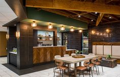 a dining room table and chairs in front of a bar with lights on the ceiling