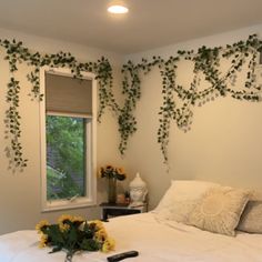 a bedroom with white bedding and green vines on the wall