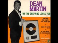 dean martin holding up a record in front of an orange and white background with the words i'm the one who loves you