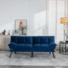 a blue couch sitting on top of a rug in a living room