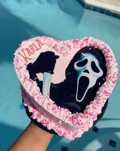 someone is holding up a cake shaped like a heart with the scream zone on it