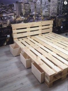 a bed made out of wooden pallets in a room with cityscape behind it