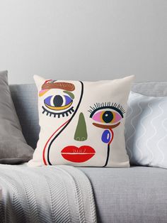 a couch with a pillow on it and a cushion in front of it that has an image of a woman's face