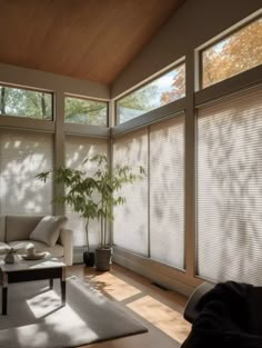 a living room with large windows covered in blinds