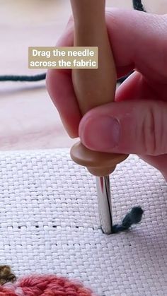 someone is crocheting the needle across the fabric with their thumbnails and finger