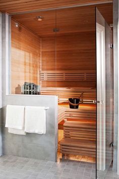 a bathroom with a sauna in the middle and towels hanging on the wall next to it