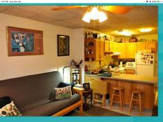 a living room filled with furniture next to a kitchen