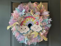 a colorful wreath with clouds and rainbows is hanging on the front door for someone to welcome