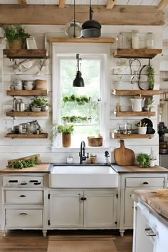 a kitchen filled with lots of open shelves next to a sink and stove top oven