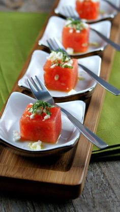 watermelon and feta cheese appetizers on small white plates with silverware