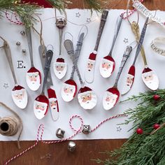 spoons decorated with santa claus's faces are sitting on a piece of paper