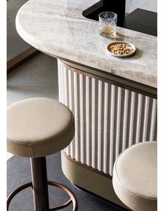 two stools sitting next to a bar with a bowl of cereal on top of it