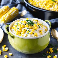 a green bowl filled with corn on the cob