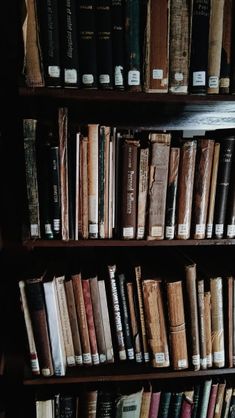 a book shelf filled with lots of books on top of wooden shelves next to each other