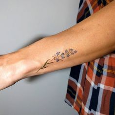 a woman's arm with a flower tattoo on the left side of her arm