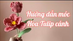 a crocheted pink flower is held up in front of a white background with the words, hoa tup canh