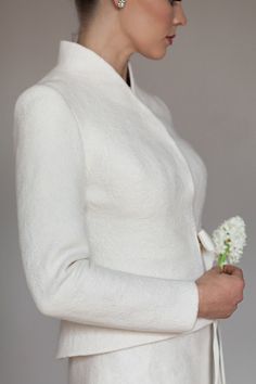 a woman in a white dress holding a flower