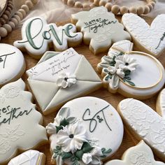 decorated cookies are arranged in the shape of letters and envelopes with flowers on them