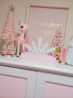 a pink and white shelf with christmas decorations on it