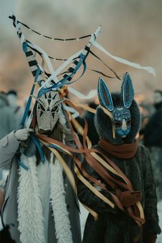 two people wearing masks and scarves with streamers in the shape of an animal's head