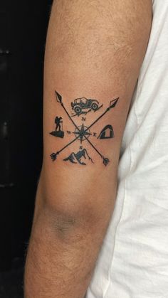 a man's arm with an arrow and compass tattoo on the left side of his arm