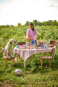 a woman sitting at a table with her dog