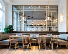 a restaurant with tables and chairs in front of a large window that overlooks the street