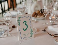 the table is set with glasses, plates and silverware for an elegant wedding reception