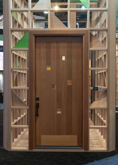 an open wooden door in front of a display case with shelves on the wall and floor