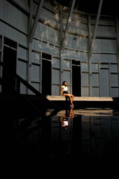 a woman is sitting on the steps in an empty building with no one around her