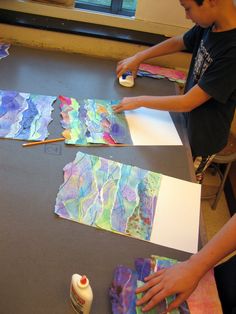 two young boys making art work on paper