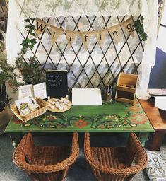 a green table topped with baskets filled with cookies and pastries next to a white curtain