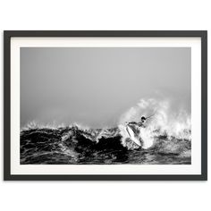 a man riding a surfboard on top of a wave in the ocean under a cloudy sky