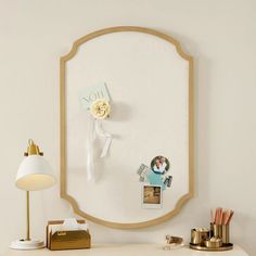 a white desk topped with a mirror next to a lamp