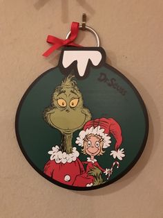 the grinch hanging on the wall has a red bow around it's neck