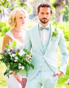 a man and woman dressed in light blue suits