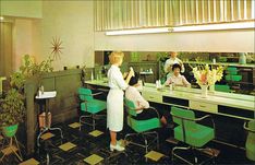 an old photo of two women sitting at a table in a diner with flowers on the counter