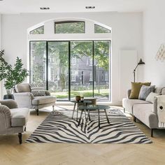 a living room filled with furniture and a zebra rug on top of a hard wood floor