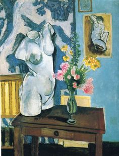 a vase with flowers on a table in front of a painting and a framed mirror