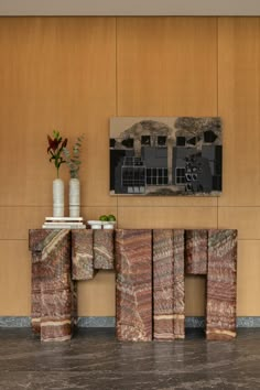 a table with two vases on top of it next to a painting and some books