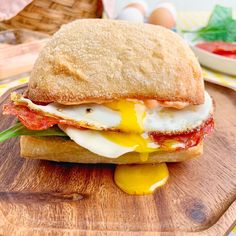 an egg and tomato sandwich is on a cutting board