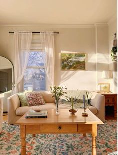 a living room filled with furniture and a large mirror on the wall above it's windows