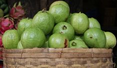 a basket filled with lots of green fruit