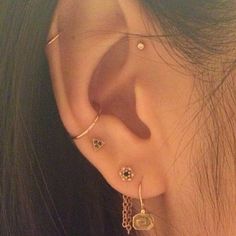 a close up of a person's ear with three different piercings on it