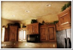 a black refrigerator freezer sitting inside of a kitchen next to wooden cabinets and cupboards