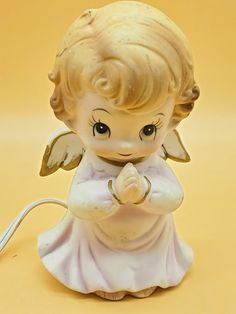 a little angel figurine holding a praying hand