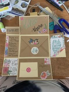 an open envelope sitting on top of a wooden table next to scissors and other items