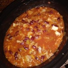 a black crock pot filled with chili and beans